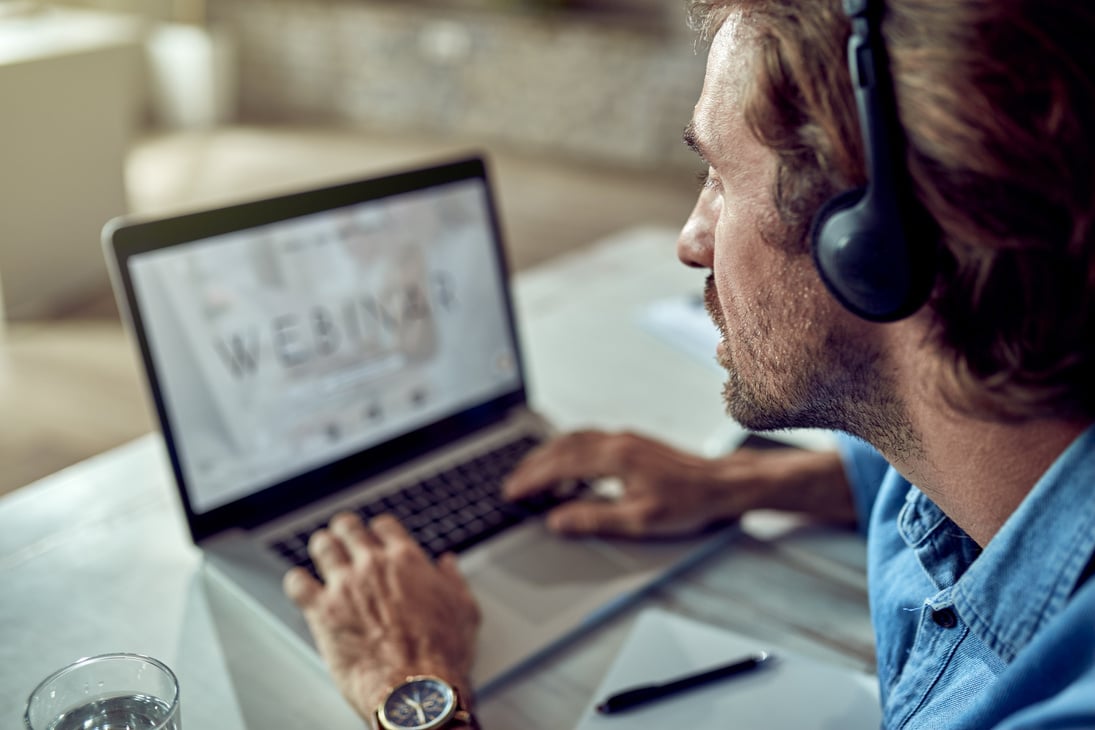 Close-up of businessman following online seminar over laptop in the office.